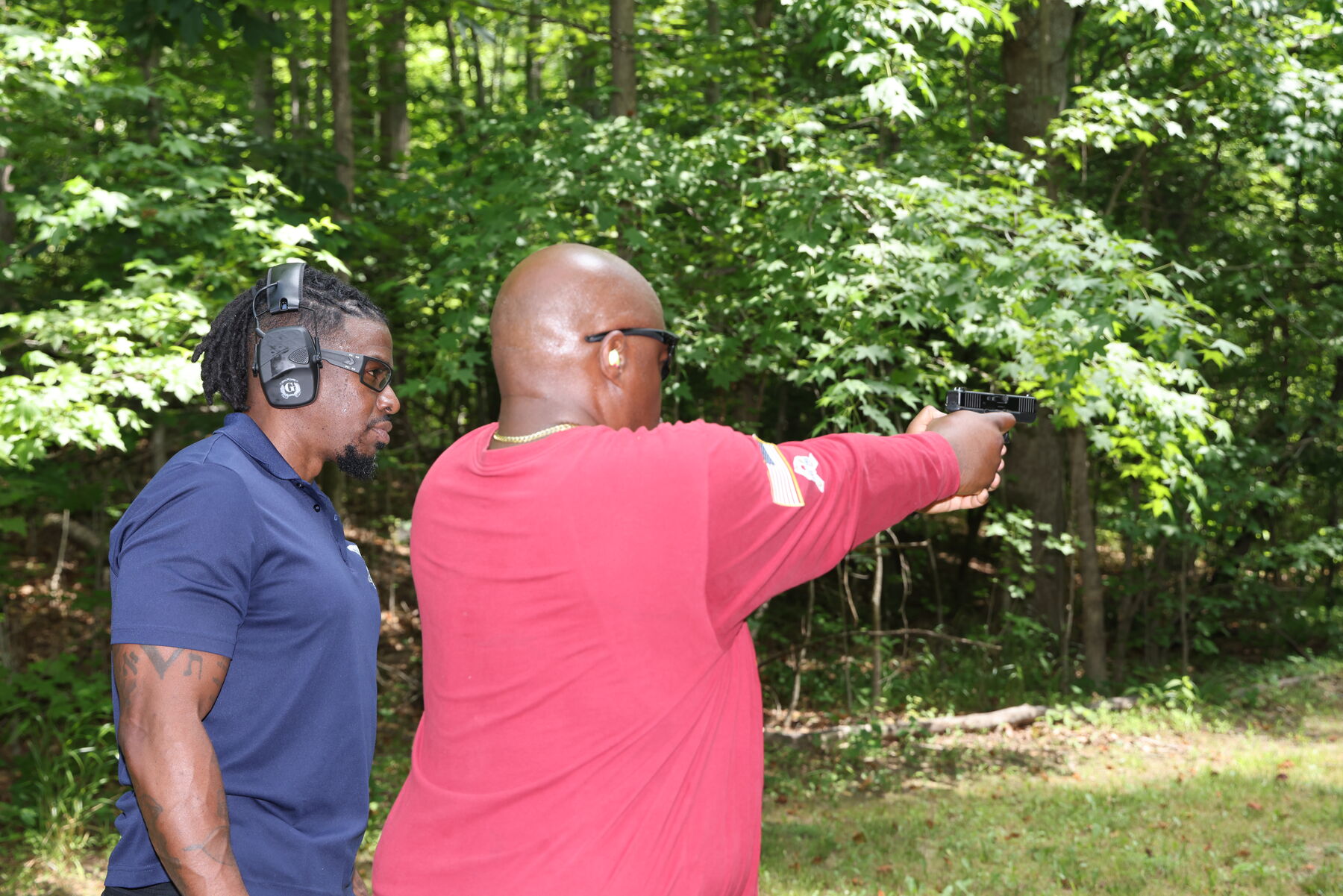 Instructor coaching a student aiming downrange
